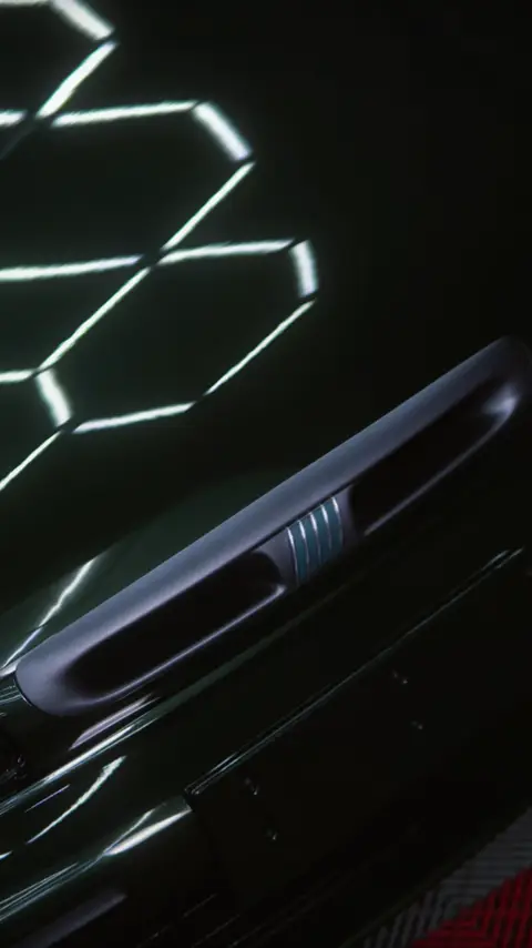 Lateral de um Fiat Marea verde-escuro refletindo luzes hexagonais